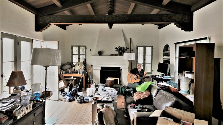 Man Playing Guitar at  Messy House